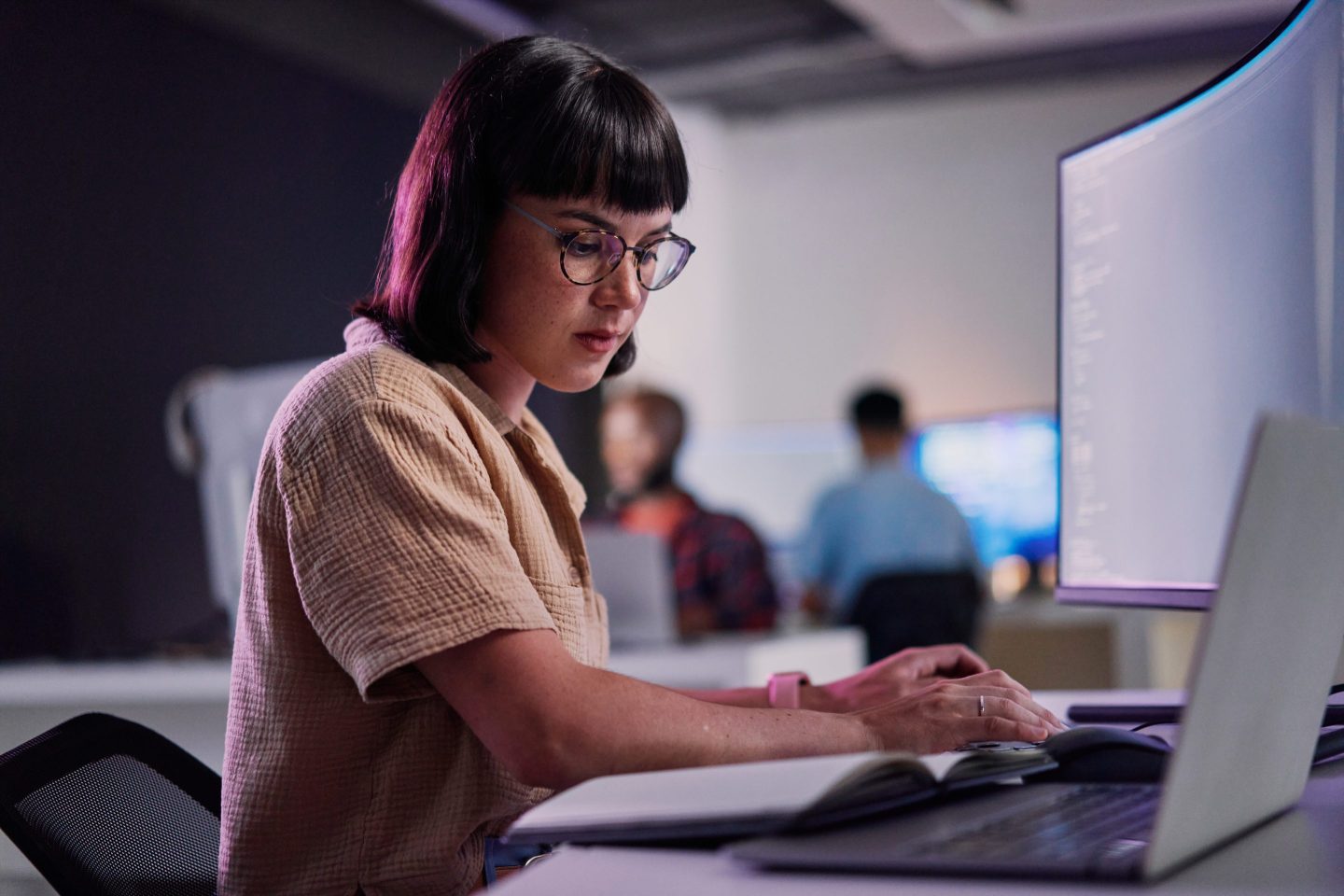 Employee sits at desk using AI chatbot.