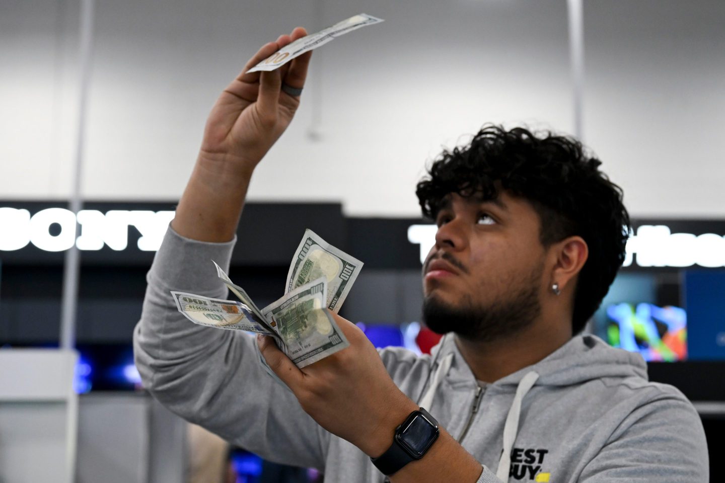 A retail employee checks banknotes during the Black Friday sale.