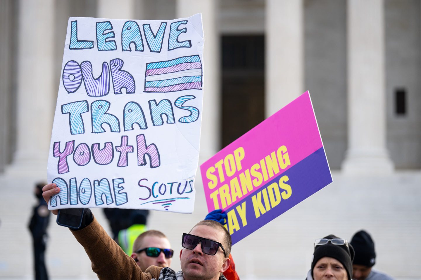 Signs against and in support of trans youth outside of the U.S. Supreme Court