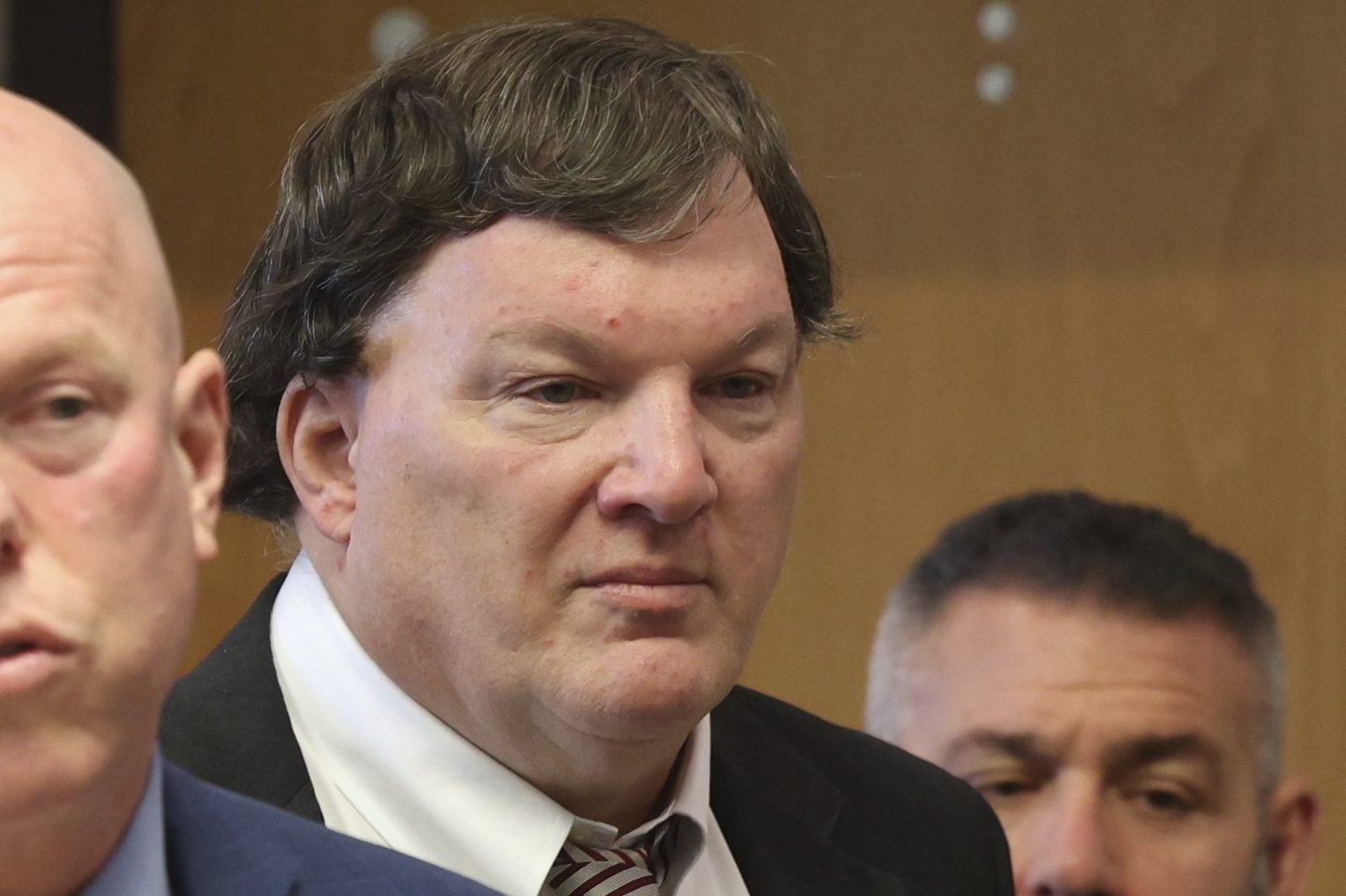 Rex Heuermann stands in a courtroom behind his lawyer