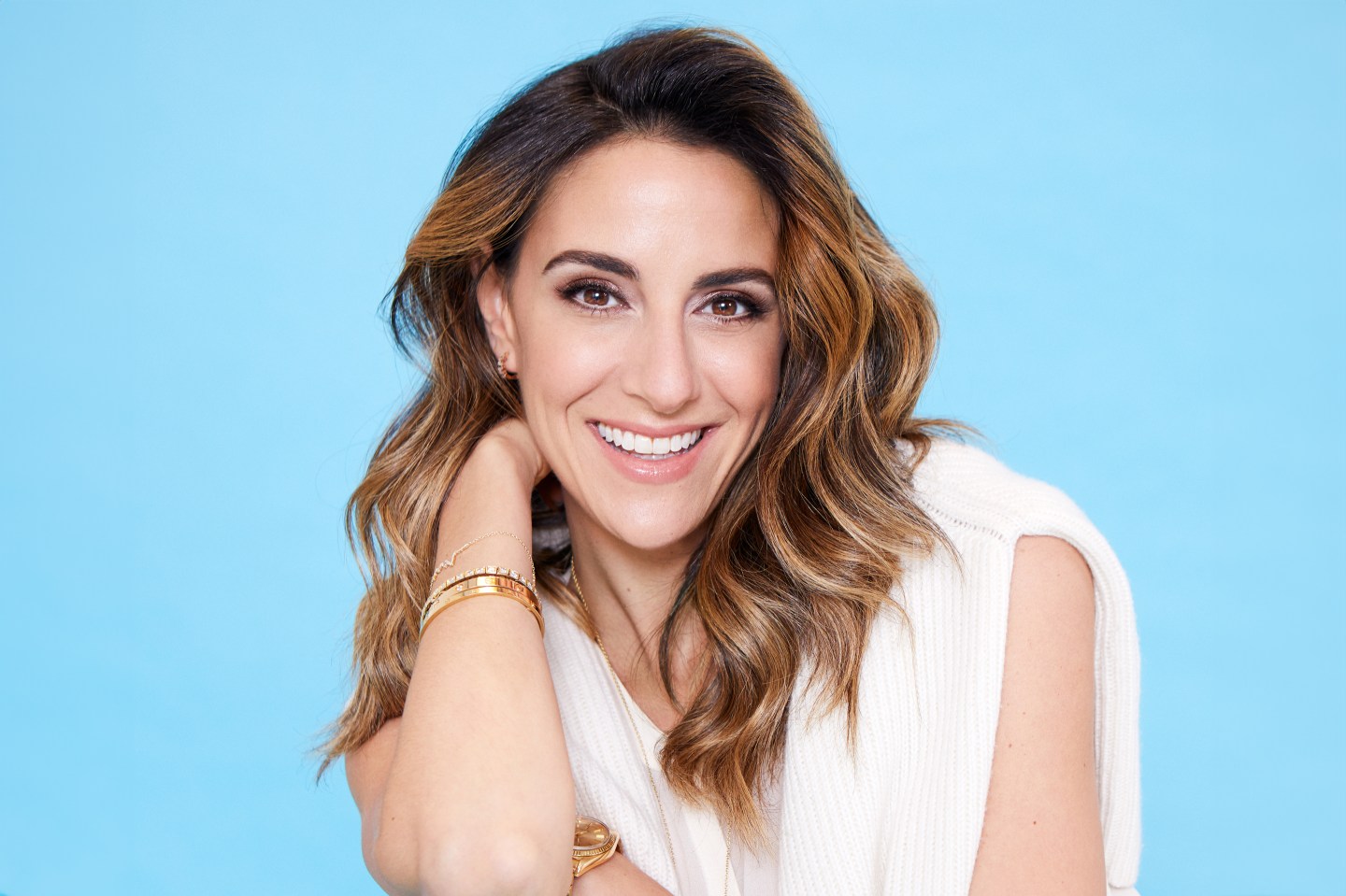 Closeup of a woman with light-brown hair on a blue background