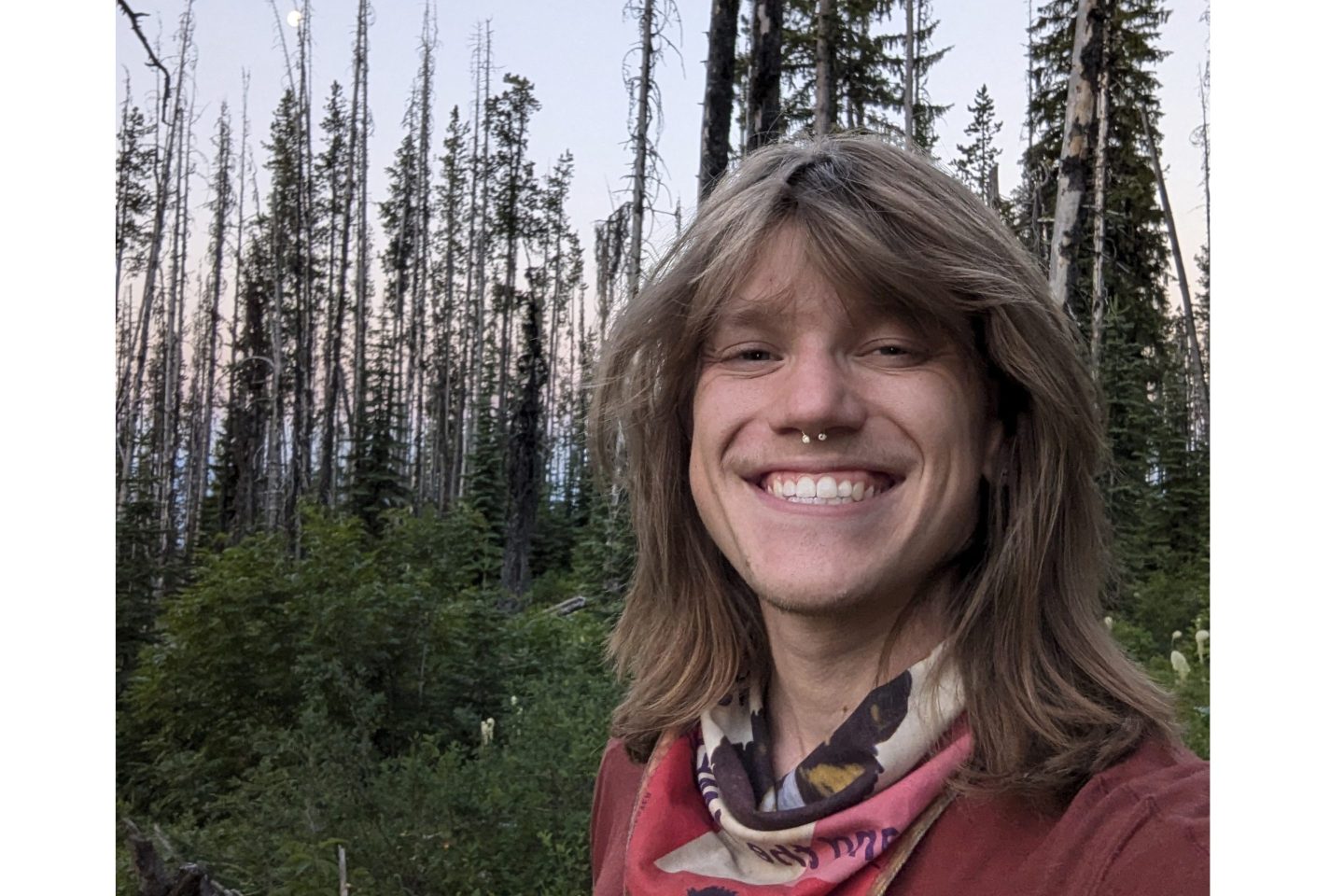 Person smiling in the woods