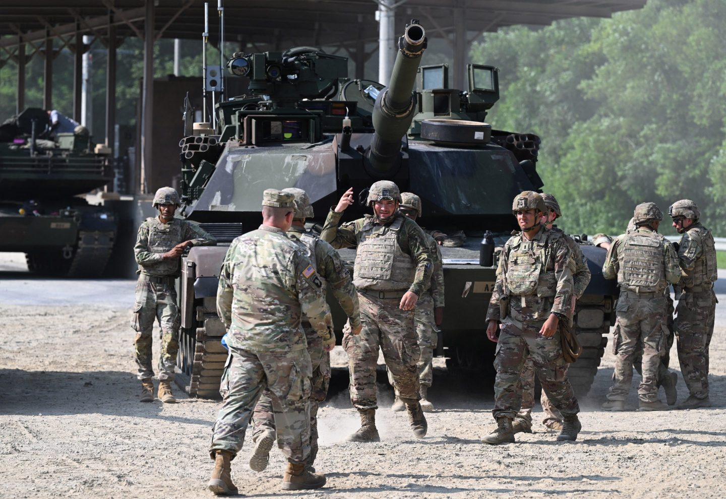 US soldiers from the 1st Armored Brigade Combat Team, 1st Armored Division stand next to a US M1A2 Abrams tank as they conduct a live-fire military drill at the Rodriguez Live Fire Complex in Pocheon on August 14, 2024, in order to master their proficiency for quick responses from the United States. (Photo by Jung Yeon-je / AFP) (Photo by JUNG YEON-JE/AFP via Getty Images)