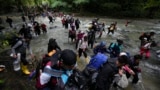 (FILE) Migrants cross a river during their journey through the Darien Gap from Colombia into Panama, hoping to reach the U.S., Oct. 15, 2022.