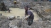 (FILE) A child gold miner works on May 5, 2014 while looking for gold in a traditional mine in the village of Gam, where gold mining in the main business activity of the region.