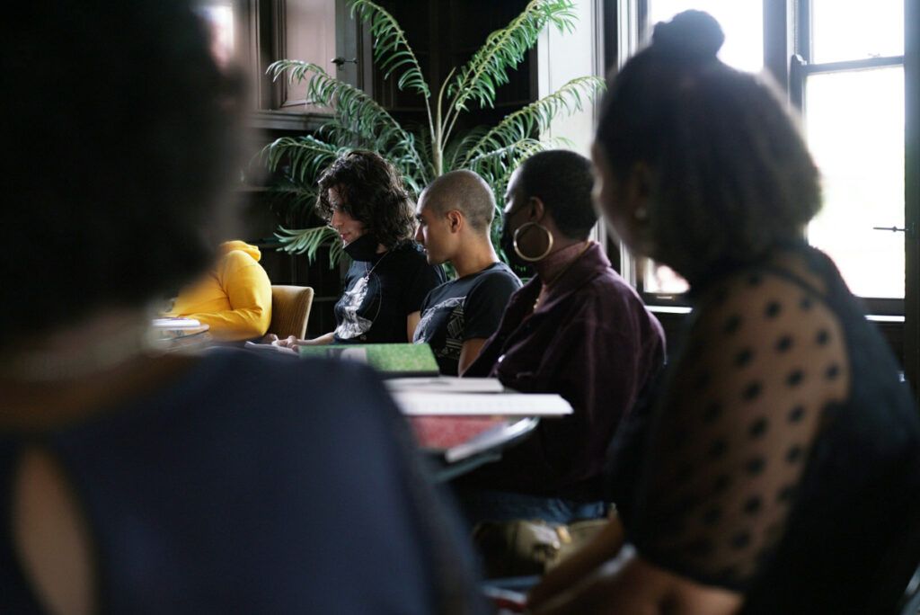 Photograph of a group of young writers sitting around a workshop table.