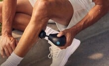 Man uses a Theragun Mini on his calf