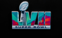 The Super Bowl LVII logo depicting a purple and green landscape hovers on a black background.