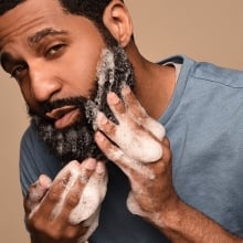 Person washing beard with foam