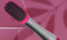 Pink and grey hairbrush over pink background