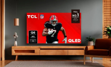 Living room scene featuring TV stand with TCL TV with football player on screen