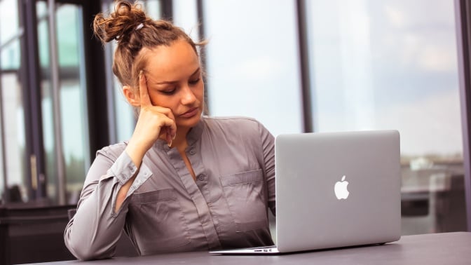 Woman sitting sad about her MacBook