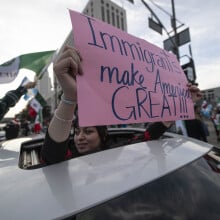 A protester holds up a sign that reads "Immigrants Make America Great!"