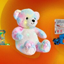 A multicolored bear, marble set, and laser tag set appear on an abstract black background.