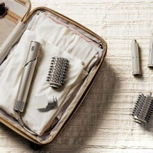 a shark flexstyle hair dryer and styler lays on an open suitcase