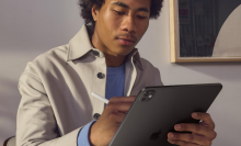 A person holding an iPad Pro