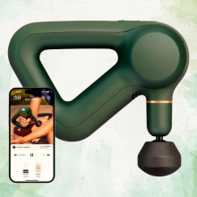 A green Theragun Prime massage gun next to a smartphone displaying the Therabody app.