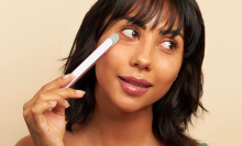 Woman using Solawave Skincare Wand on her cheek, looking off to the side