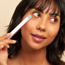 Woman using Solawave Skincare Wand on her cheek, looking off to the side