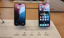 Two iPhones laying on a table at the Apple Store