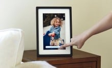 a slylight digital photo frame displays an image of a young girl while it sits on a tabletop