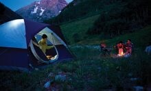 Person coming out of a tent at dusk