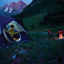 Person coming out of a tent at dusk