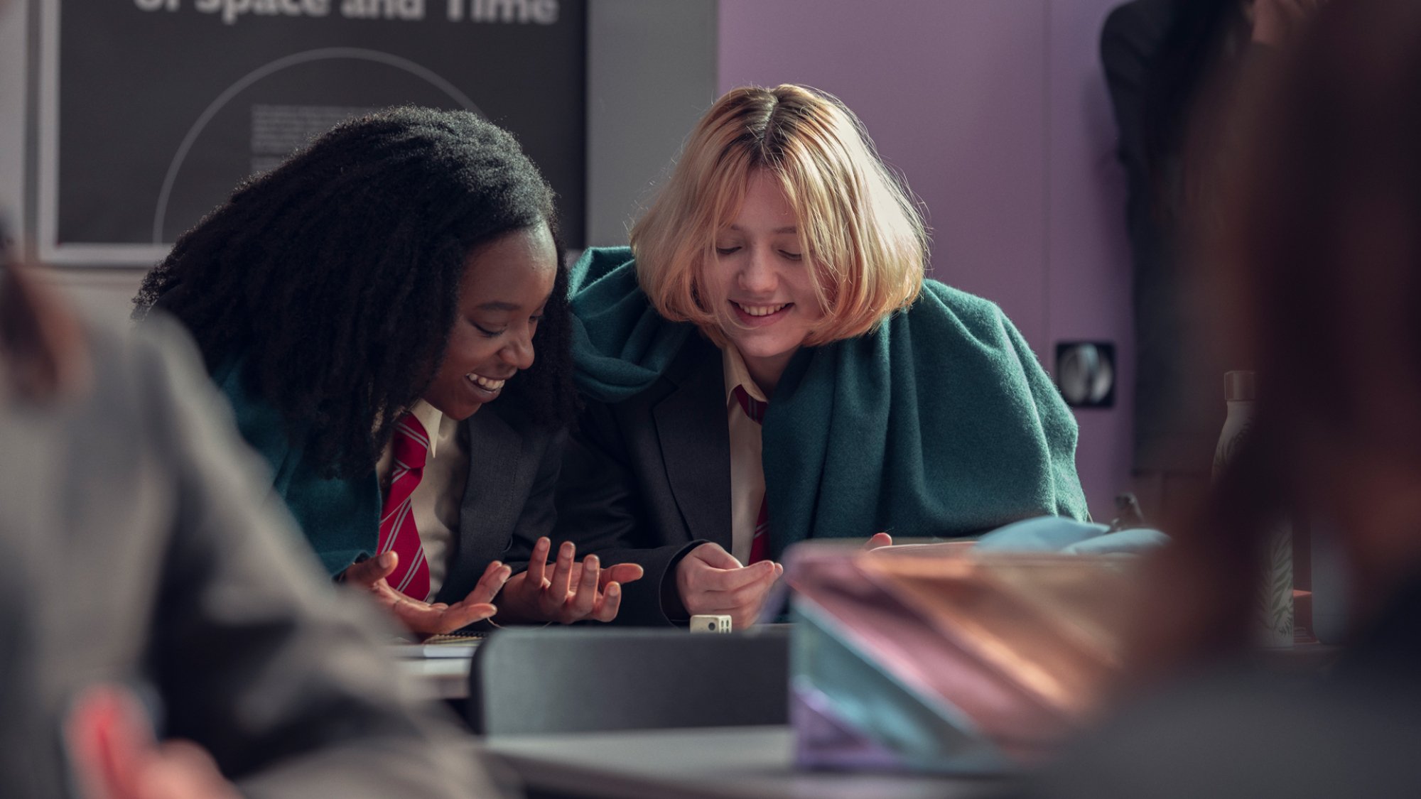 Tara and Darcy (Corrina Brown and Kizzy Edgell) laugh in class in "Heartstopper."