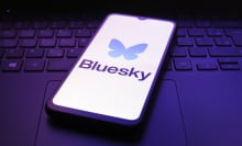 bluesky logo on phone on top of keyboard