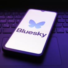 bluesky logo on phone on top of keyboard