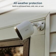 an arlo spotlight security camera affixed to the side of a house