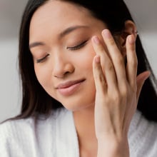 Woman putting skincare on her face