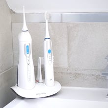 The electric toothbrush and water flosser set from Toiletree standing in someone's bathroom.