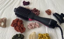 A Revlon One-Step surrounded by hair accessories.