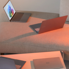 Four laptops in various open positions laying on couch and table