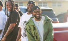 Kendrick Lamar smiles alongside Jay Rock, center, in between filming for the the music video for "Not Like Us" at Nickerson Gardens on Saturday, June 22, 2024 in Watts, CA.