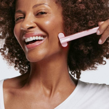 woman smiling and using a solawave skin wand 