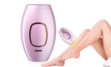 purple electronic laser hair removal device next to a shaved leg