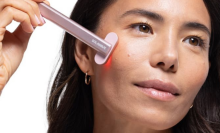 Woman using rose gold SolaWave skincare wand 