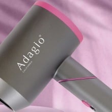 Adagio Accelerator 2100 Foldable Blow Dryer on a pink background.