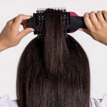 person styling the hair at the top of their head with the revlon one-step