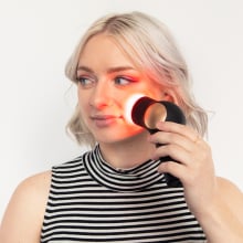 woman holding theraface pro device up to her face