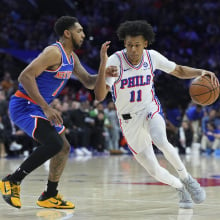  Jeff Dowtin Jr. #11 of the Philadelphia 76ers dribbles the ball to the basket against Cameron Payne #1 of the New York Knicks in the first half at the Wells Fargo Center on January 15, 2025 in Philadelphia, Pennsylvania. 