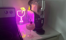 Ninja Slushi frozen drink maker. margarita glass, and neon light decoration sitting on countertop