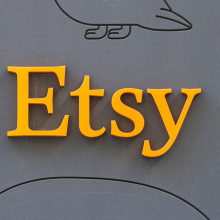 The Etsy logo in orange on a grey background.