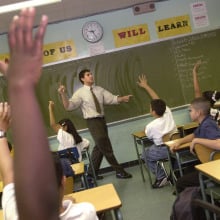 kids in a classroom raising their hands