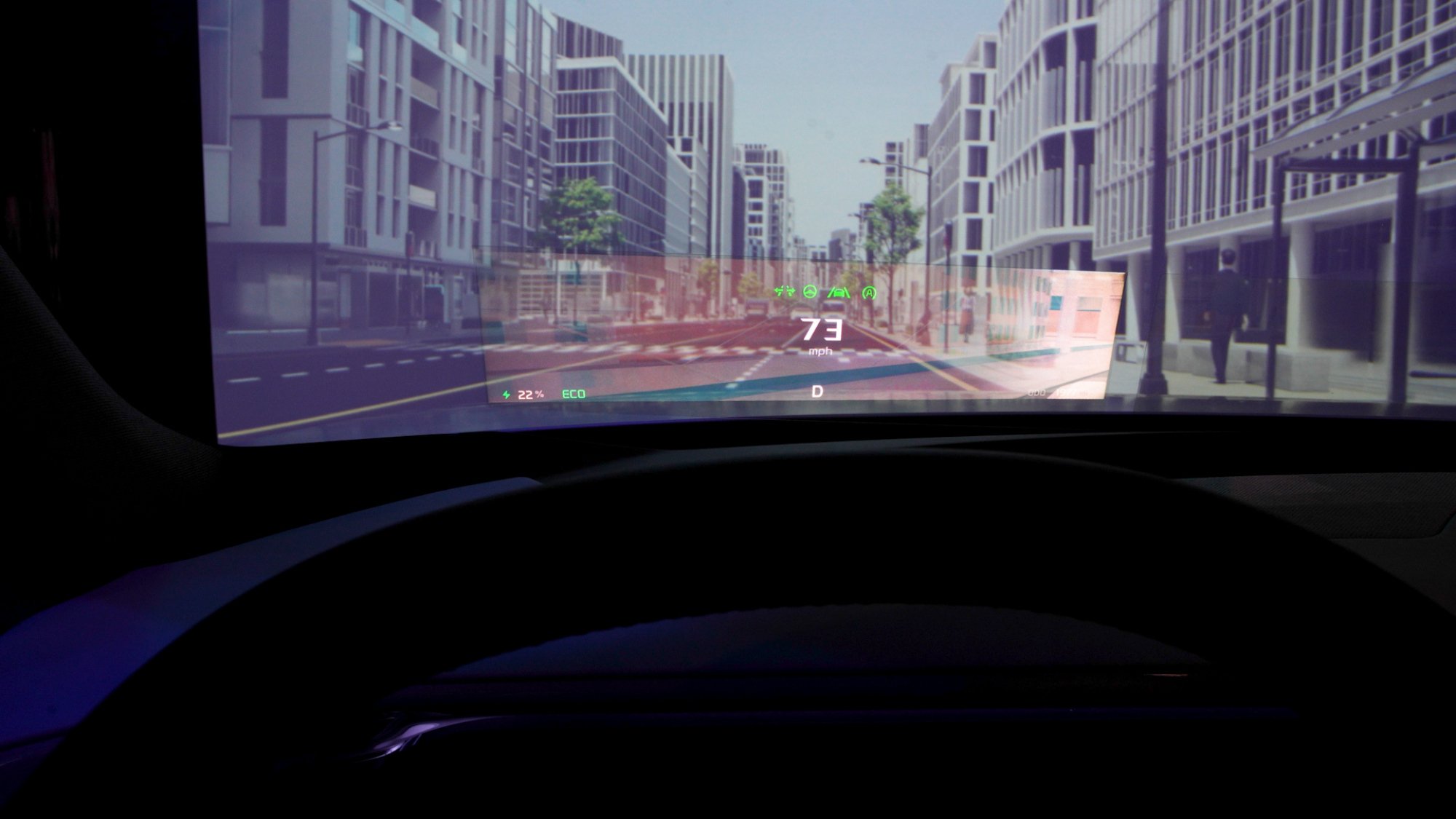 A futuristic in-car augmented reality display showing a virtual cityscape overlay with driving data such as speed (73 mph), battery percentage (22%), and eco mode.