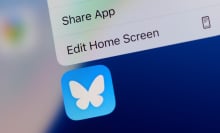 The Bluesky app logo on an iPhone home screen. 