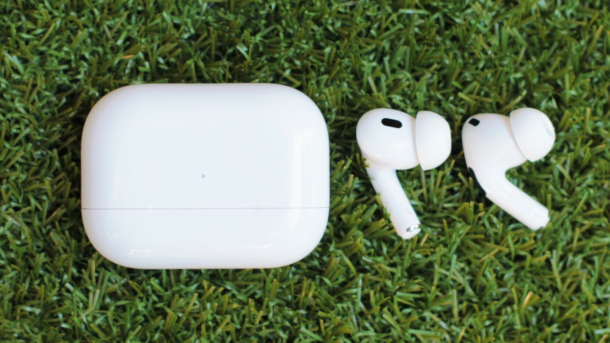 airpods with case on grass