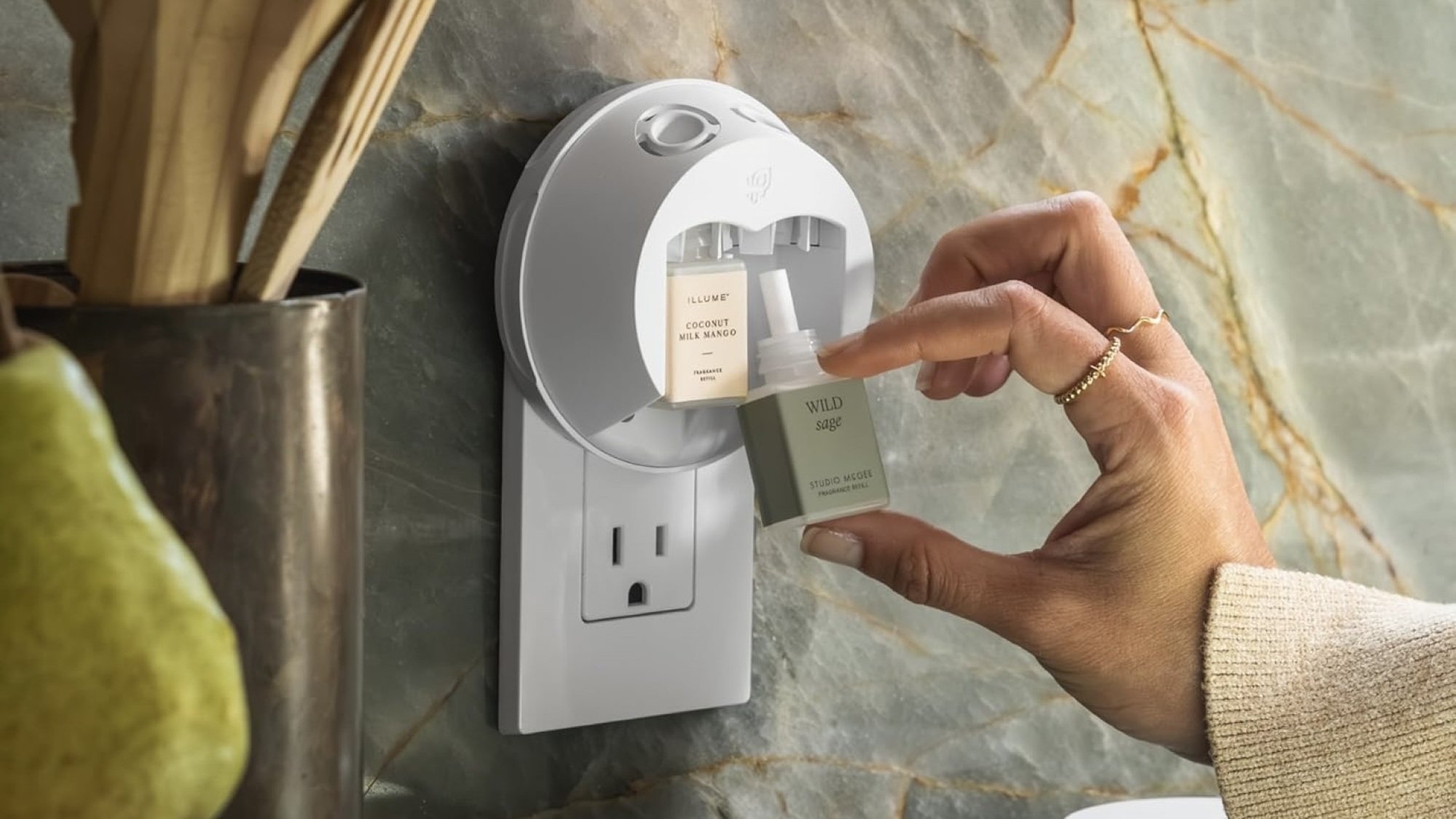 person putting fragrance in wall diffuser